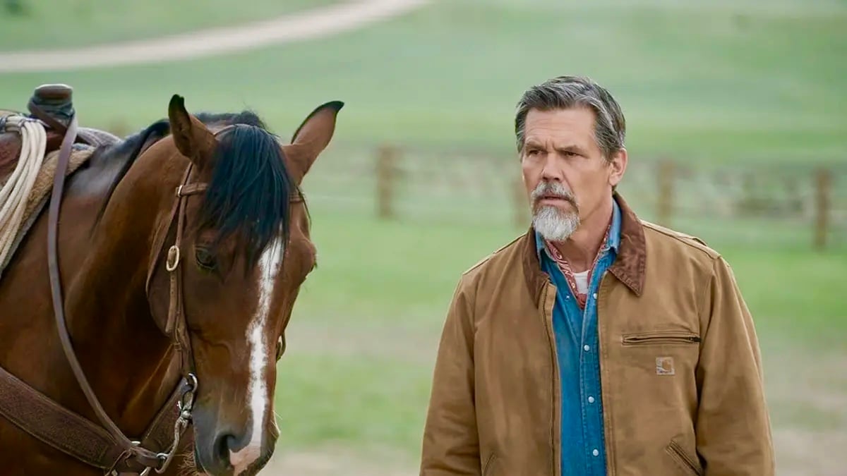 Josh Brolin stands next to a brown horse in an open field for a promotional shoot for the TV show ‘Outer Range.’