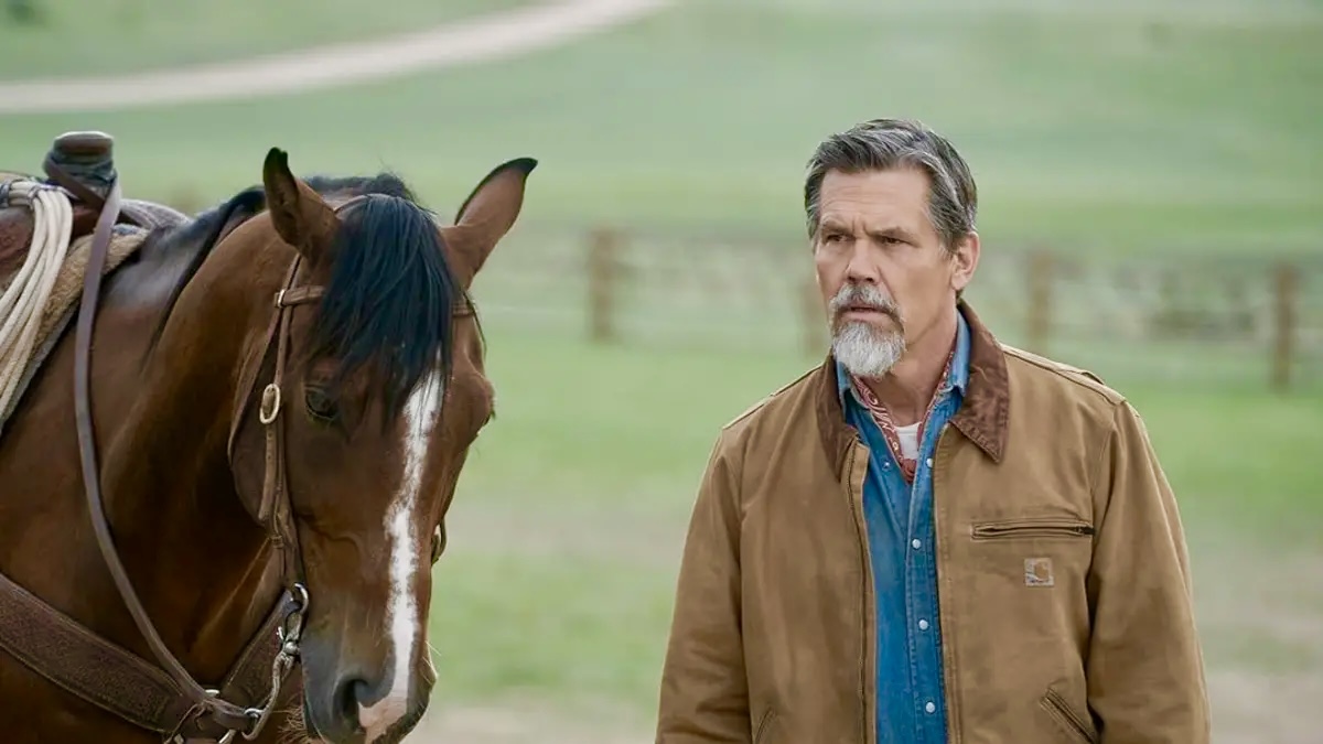 Josh Brolin stands next to a brown horse in an open field for a promotional shoot for the TV show ‘Outer Range.’