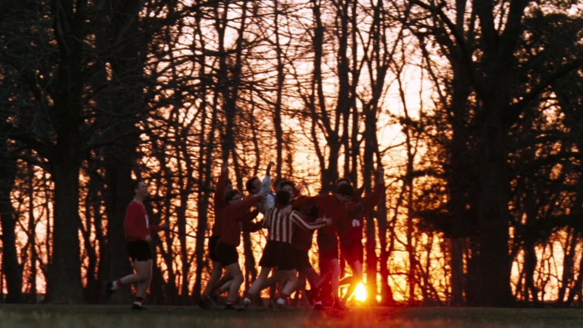 Les garçons de la « Dead Poet Society » soulèvent Robin Williams avec le coucher de soleil derrière eux.