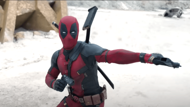 Deadpool holds his gun sideways while standing in front of a destroyed 20th Century Fox effigy in the Deadpool & Wolverine trailer