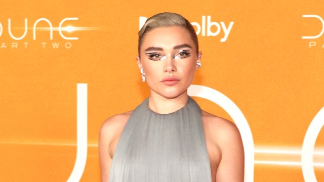 Florence Pugh in a silver dress against an orange backdrop at the 'Dune: Part Two' premiere in NYC
