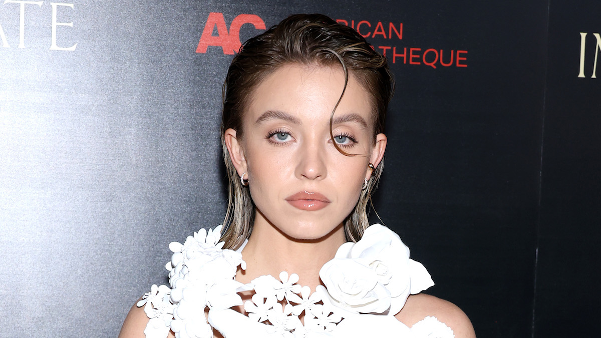 Sydney Sweeney looking sassy in a white dress with a stray strand of hair at the 'Immaculate' premiere