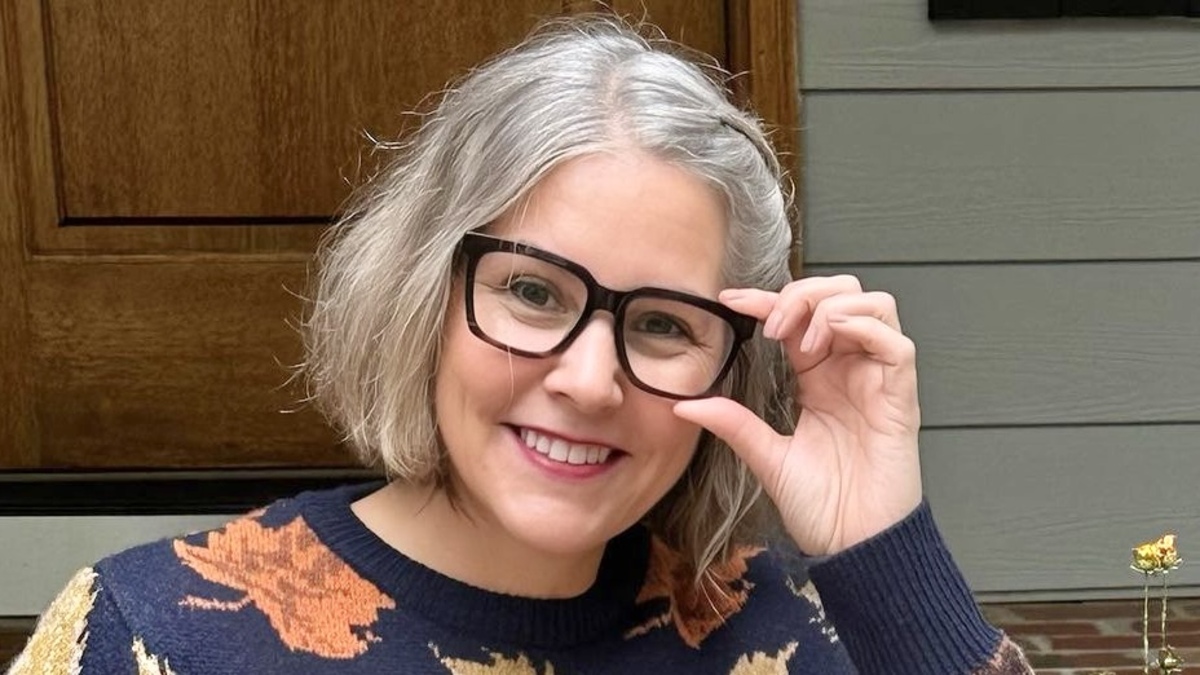 NYT best-selling author Ellery Adams poses in glasses and smiles