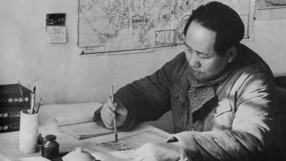 Chairman Mao Zedong (1893 - 1976) of the Communist Party of China writing with a brush at his desk in a cave headquarters in north-west China during the Chinese Civil War, 1948. 