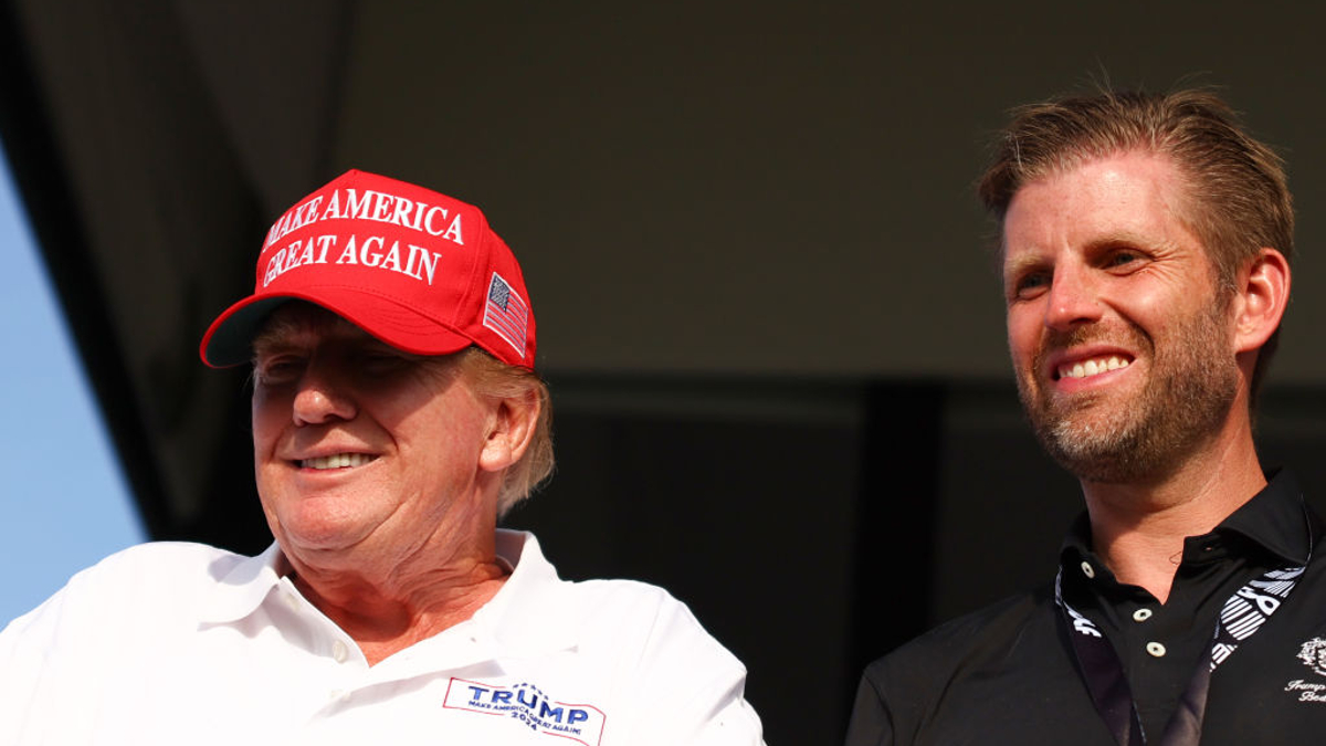 Former U.S. President Donald Trump and son Eric Trump look on at the 18th green during day three of the LIV Golf Invitational - Miami at Trump National Doral Miami on April 07, 2024 in Doral, Florida.