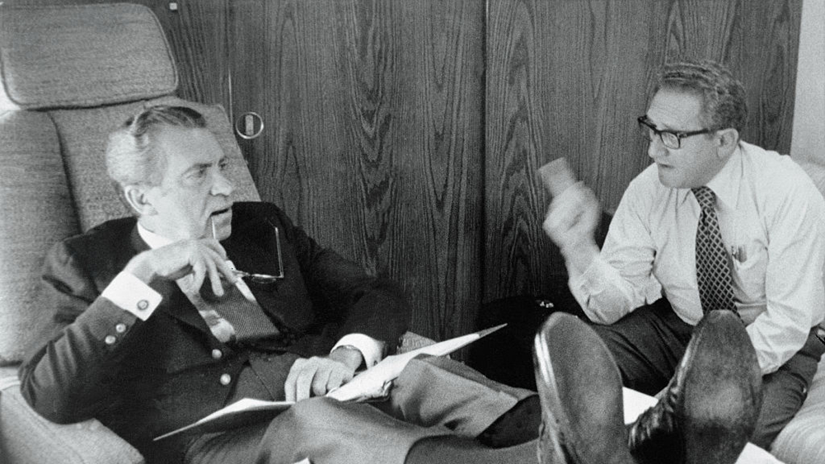 Famous war criminals President Richard Nixon and Secretary of State Henry Kissinger confer aboard Air Force One as it heads towards Brussels, Belgium, June 26th, and NATO talks. Nixon rests his legs on a pillow atop a table to ease an attack of Phlebitis which struck recently. After the Brussels talks, President Nixon headed for Moscow and summit talks with Soviet leader Leonid Brezhnev.