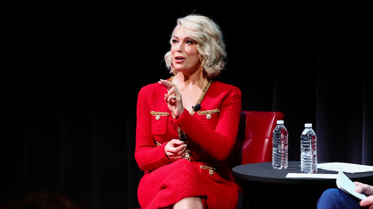 Hannah Waddingham in a red dress sitting on stage at her 2024 career retrospective