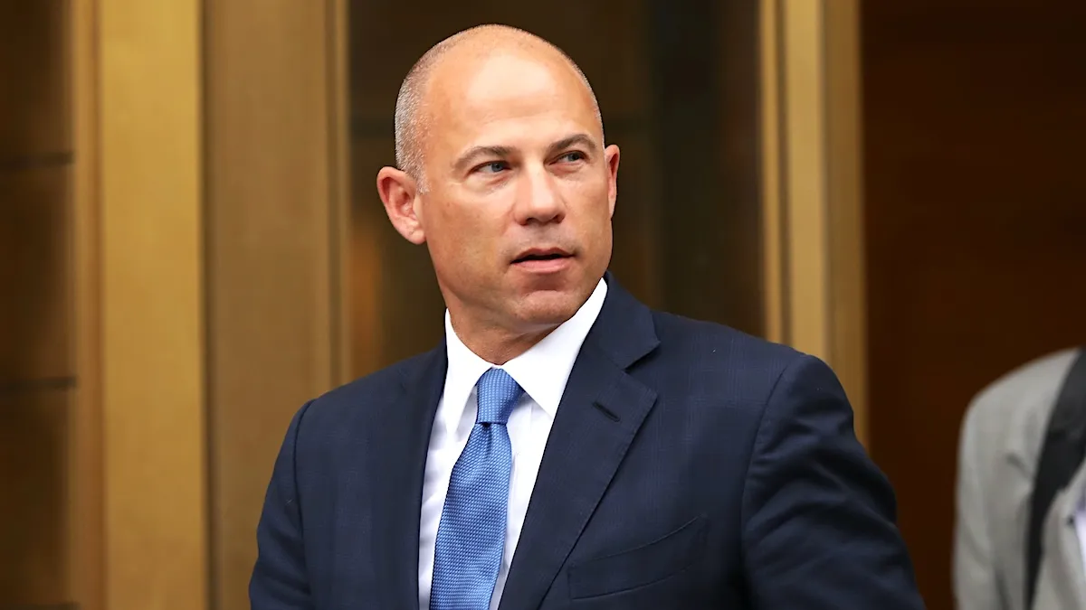 Michael Avenatti in a suit and blue tie walking out of a courthouse