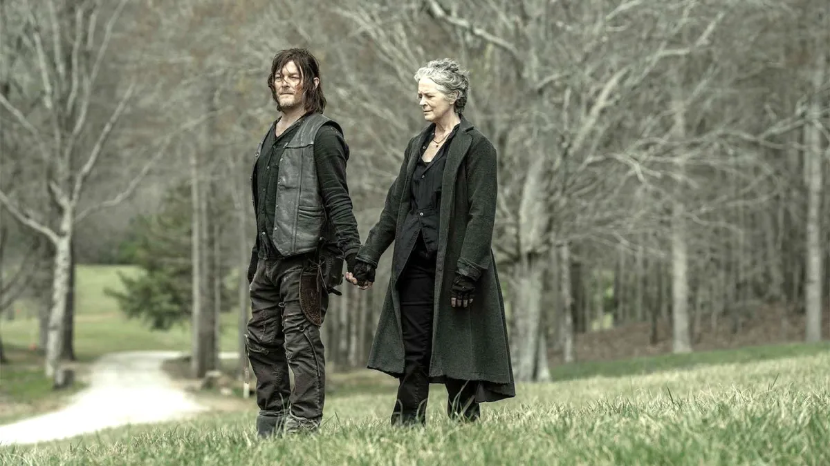 Daryl (Norman Reedus) and Carol (Melissa McBride) hold hands in the wilderness in The Walking Dead series finale