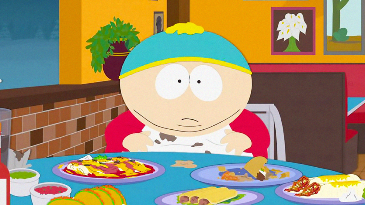 Cartman eating food with a napkin around his neck in South Park