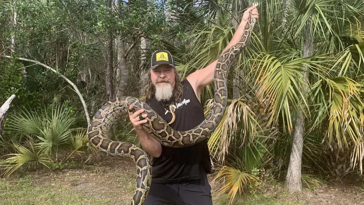 Dusty Crum holding a python in Swamp People