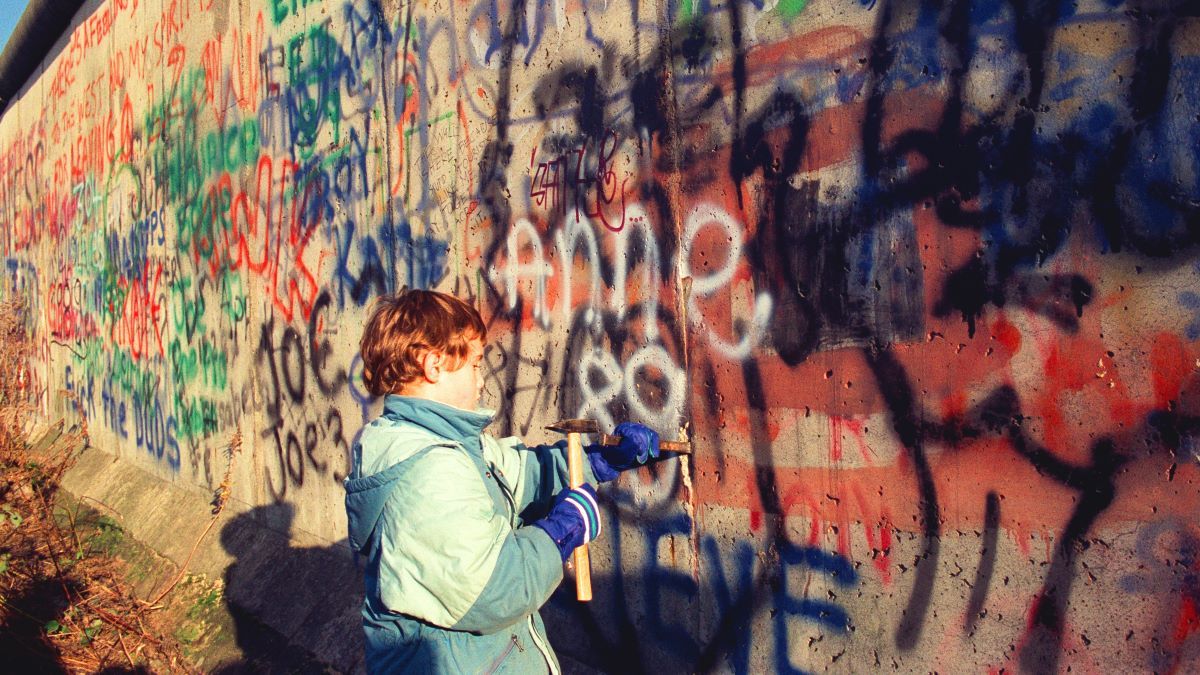 A child hammering the Berlin Wall, Berlin, Germany, 10th November 1989. (Photo by Colin Campbell/Getty Images)