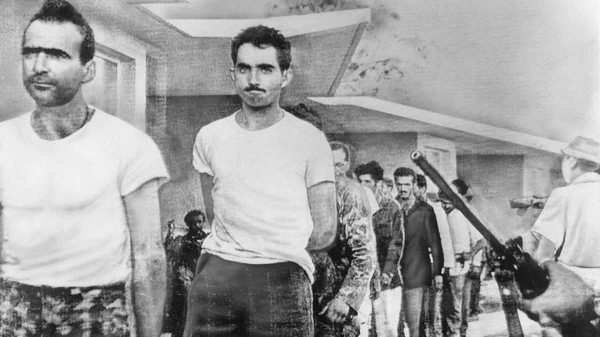 -Havana, Cuba- Watched by armed guards, grim-faced invaders are marched off to prison from temporary quarters at Giron Beach, Las Villas province, after their capture by Castro forces. This is one of the first pictures received by Telephoto from United Press International's Havana bureau after restoration of communications.