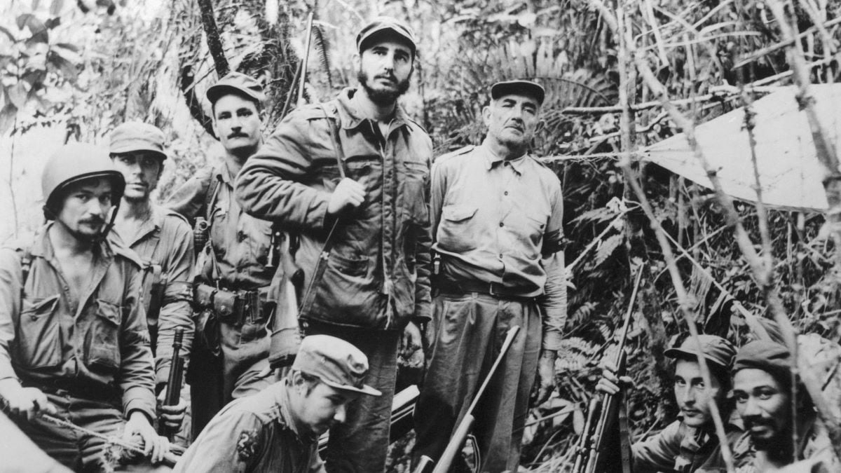 This photo, filed June 1957, is believed to be the only existing one of Fidel Castro, leader of Cuba's revolutionary forces, and members of his staff and troop commanders made at a secret base near the coast. The group includes five captains, the entire top command of the guerilla army. From right are Capt. Juan Almeida, Capt. George Sotus, Fidel Castro, Capt. Raul Castro, the leader's younger brother (kneeling in the foreground), Capt. Guillermo Garcia, (wearing helmet at left), Lt. Universo Sanchez, Castro's adjutant, (third from left) and Dr. Ernesto Guevara, (second from left), the official physician of the rebel army.