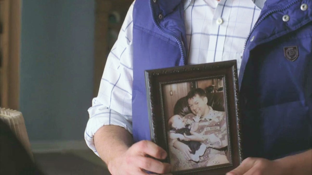 Burt Hummel holding a picture of Christopher Hudson and Finn Hudson in Glee season 1