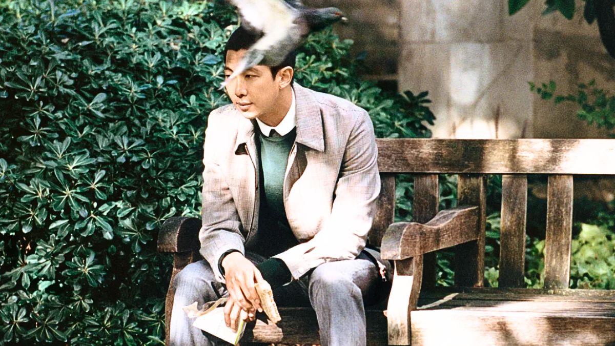 RM sits in a bench in a concept photo for his album 'Right Place Wrong Person'.