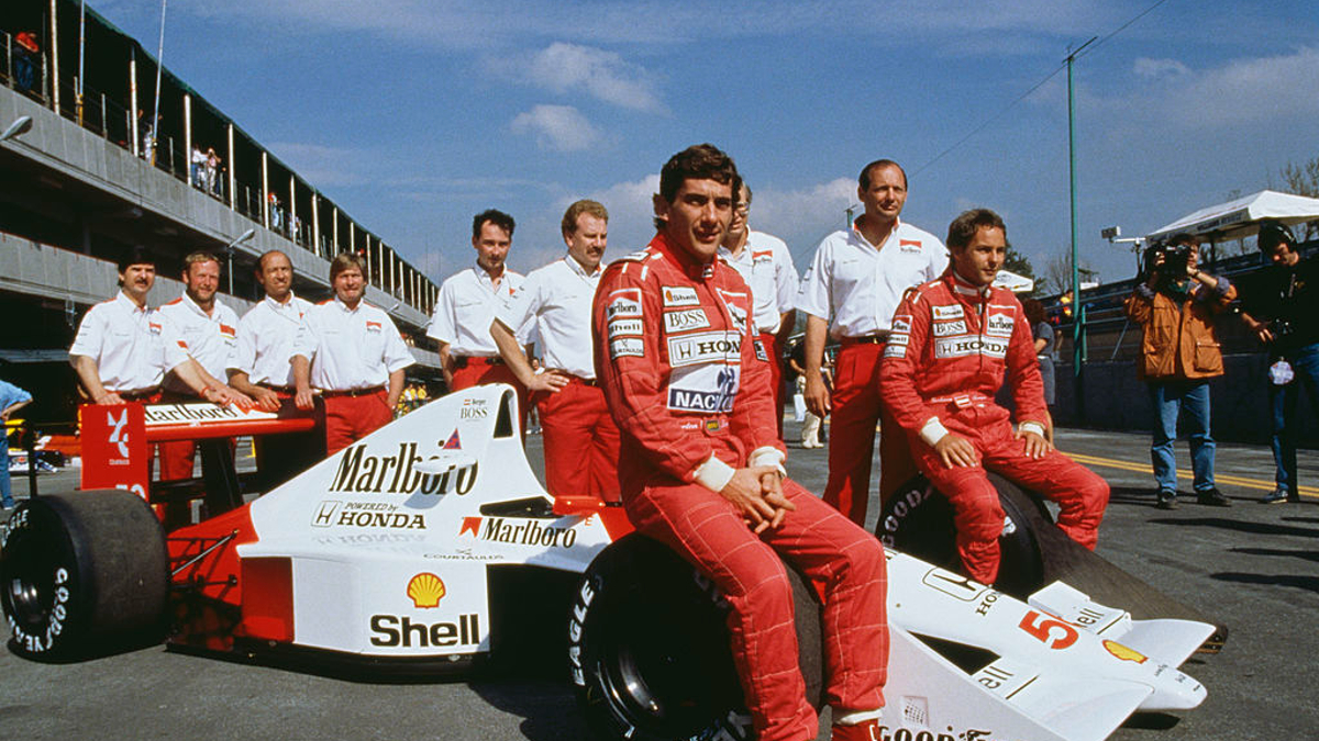 Ayrton Senna (1960 -1994, centre) and his Austrian teammate Gerhard Berger (right) pose with the rest of the McLaren team at the Mexican Grand Prix at the Mexico City circuit, 24th June 1990.