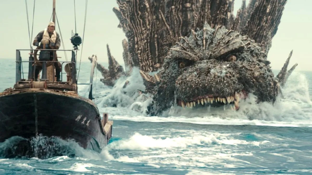 Godzilla swimming toward a boat firing a machine gun at him.
