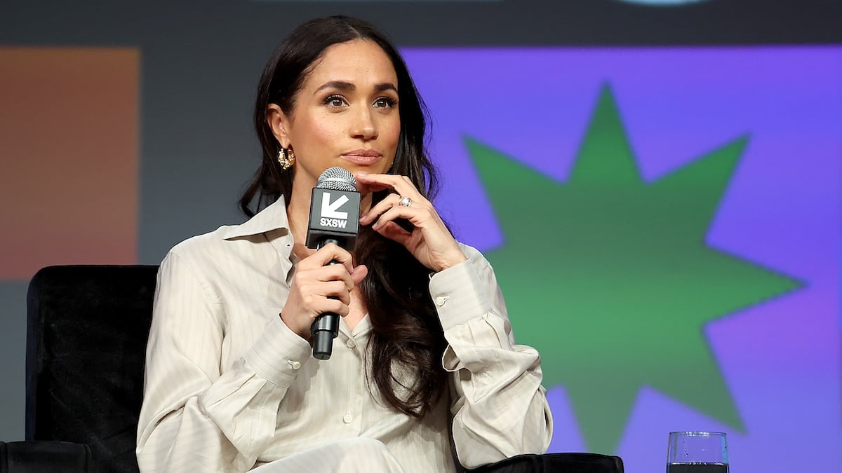 Meghan, Duchess of Sussex holds a microphone while speaking onstage