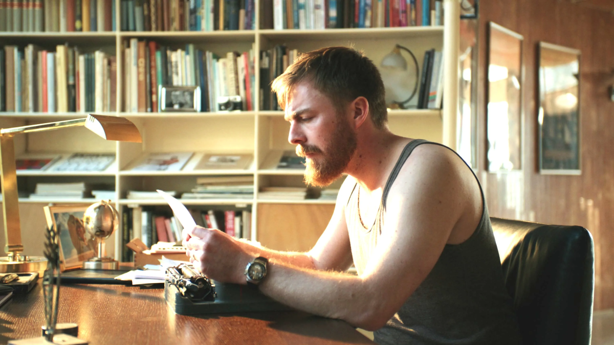 A man sitting at a desk with a typewriter.