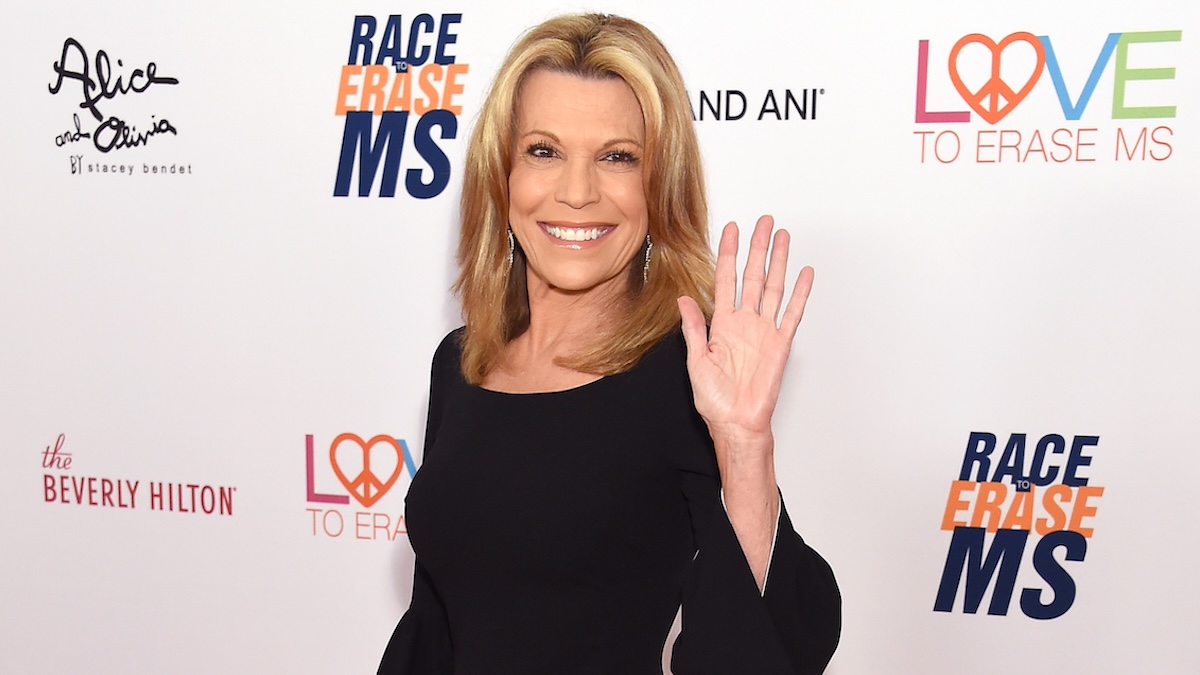 Vanna White on the red carpet, waving at the photographer