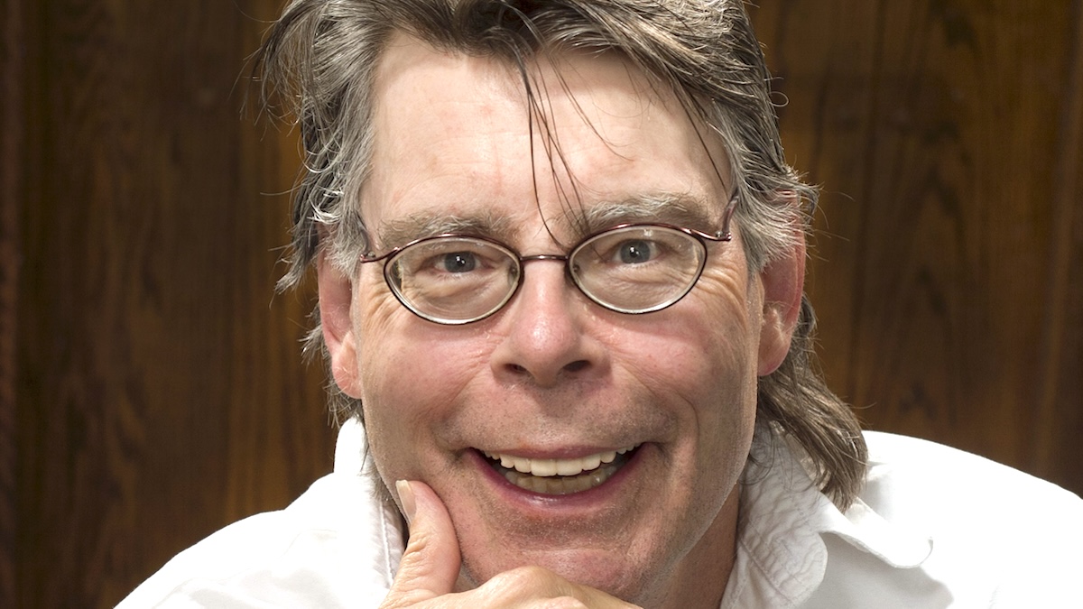 Stephen King wearing glasses and shamelessly displaying what looks like a mullet