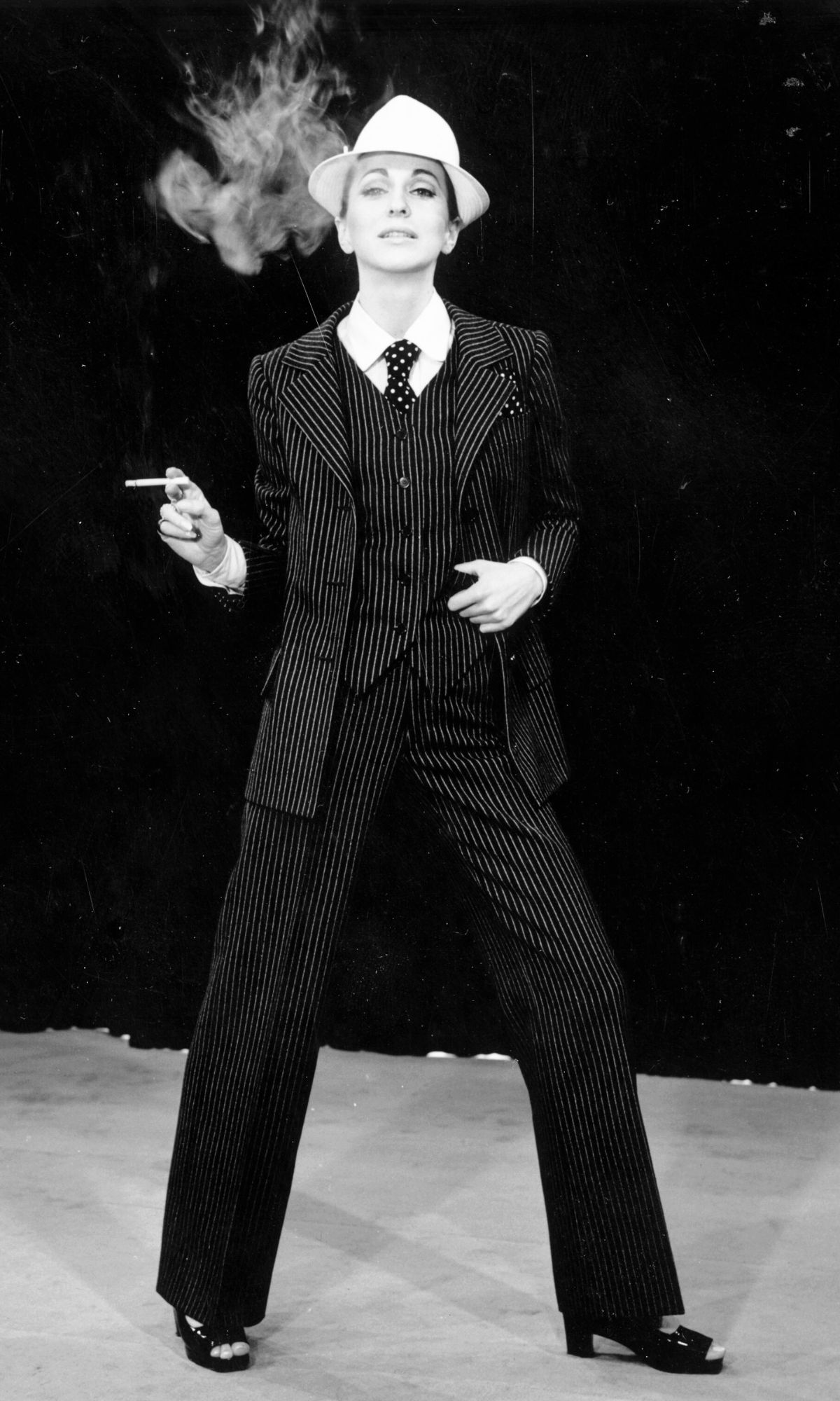 A model strikes a masculine look wearing a pinstriped trouser suit by Yves Saint Laurent, 23rd February 1967. His plainer suit for evening wear known as 'Le Smoking' became his signature piece. 