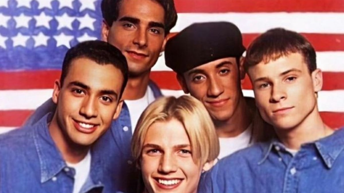 The Backstreet Boys posing in front of an American flag