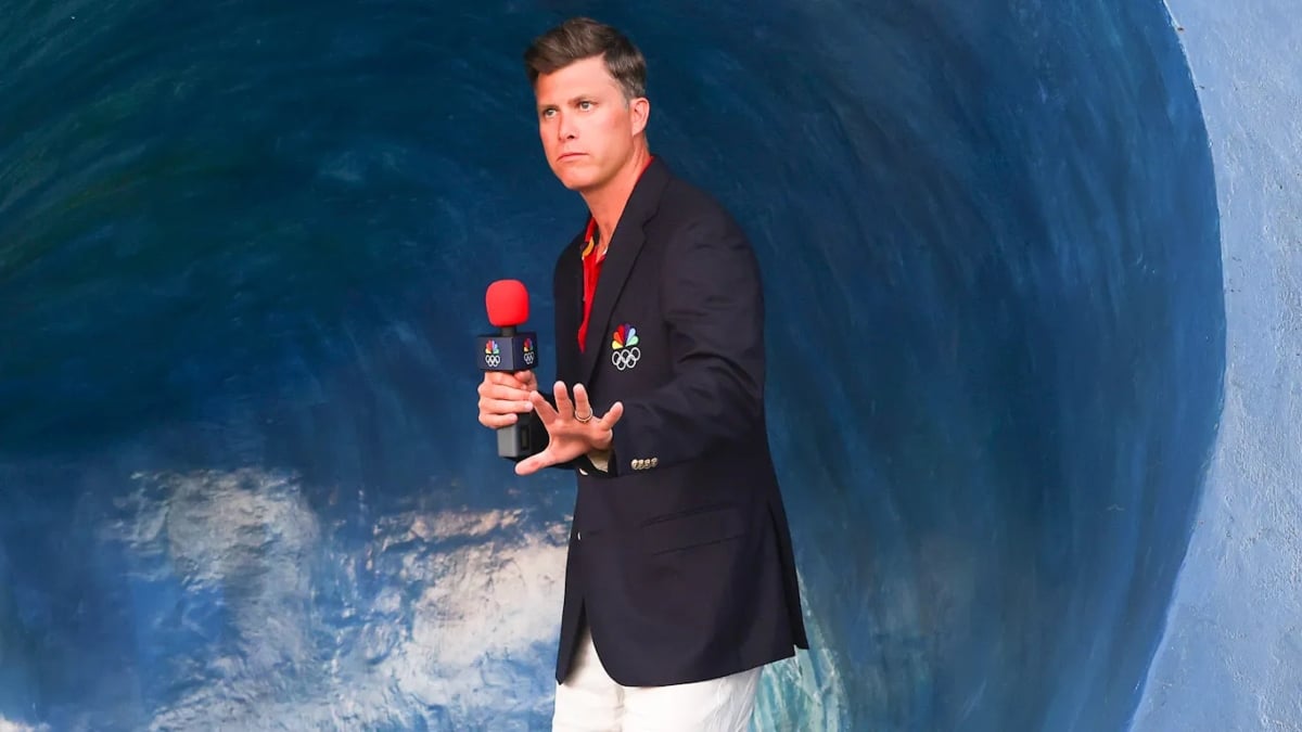 Colin Jost standing in front of a wave
