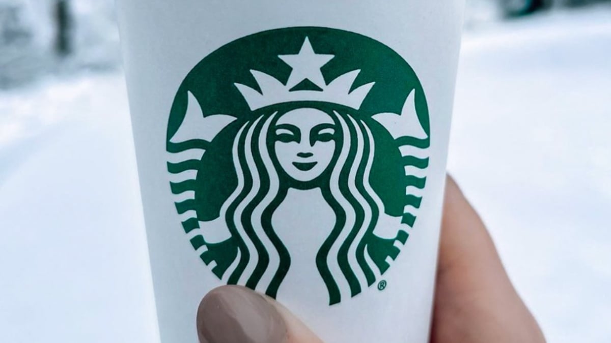 A photo of a hand holding a Starbucks coffee cup