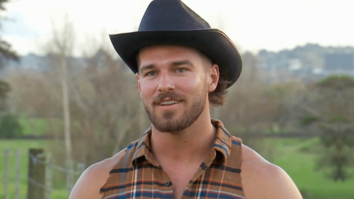 Austin Ott wearing a cut-off shirt and a cowboy hat in 'The Bachelorette' season 21