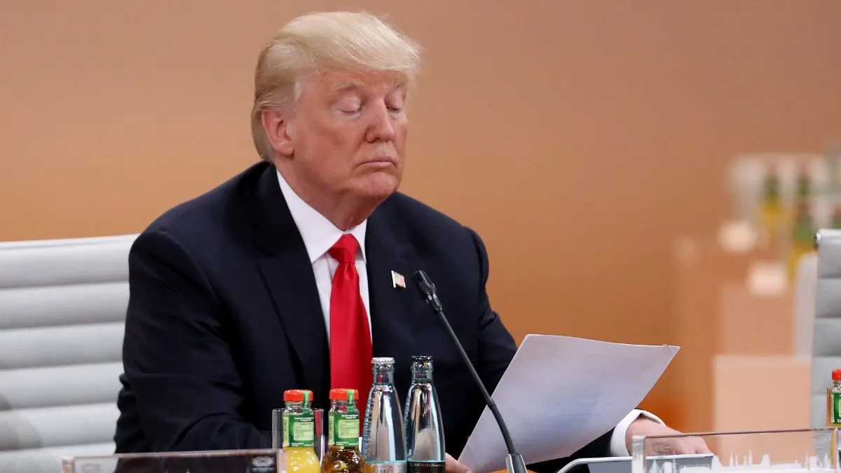 HAMBURG, GERMANY - JULY 08: U.S. President Donald Trump reads a document prior to the morning working session on the second day of the G20 economic summit on July 8, 2017 in Hamburg, Germany. G20 leaders have reportedly agreed on trade policy for their summit statement but disagree over climate change policy. (Photo by Sean Gallup/Getty Images)