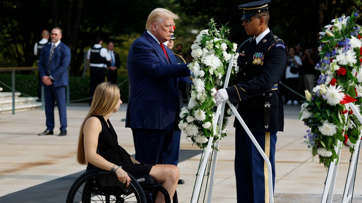 Donald Trump lays a wreath alongside Marine Kelsee Lainhart, who was injured at the Abbey Gate Bombing, during a wreath-laying ceremony at the Tomb of the Unknown Soldier at Arlington National Cemetery