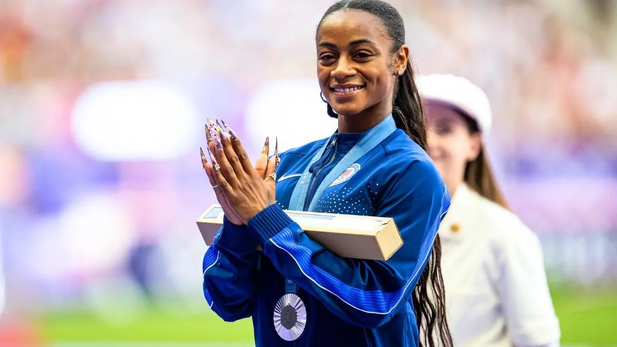 Silver medalist Sha'Carri Richardson of Team United States celebrates on the podium during Women's 100m medal ceremony on day nine of the Olympic Games Paris 2024 at Stade de France on August 4, 2024 in Paris, France.