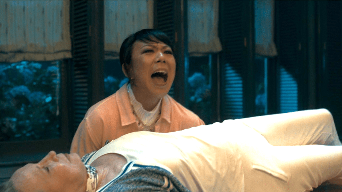 Alice Wu-Gulliver screams while Sharon Davis lays unconscious on the table in front of her in Agatha All Along episode 3