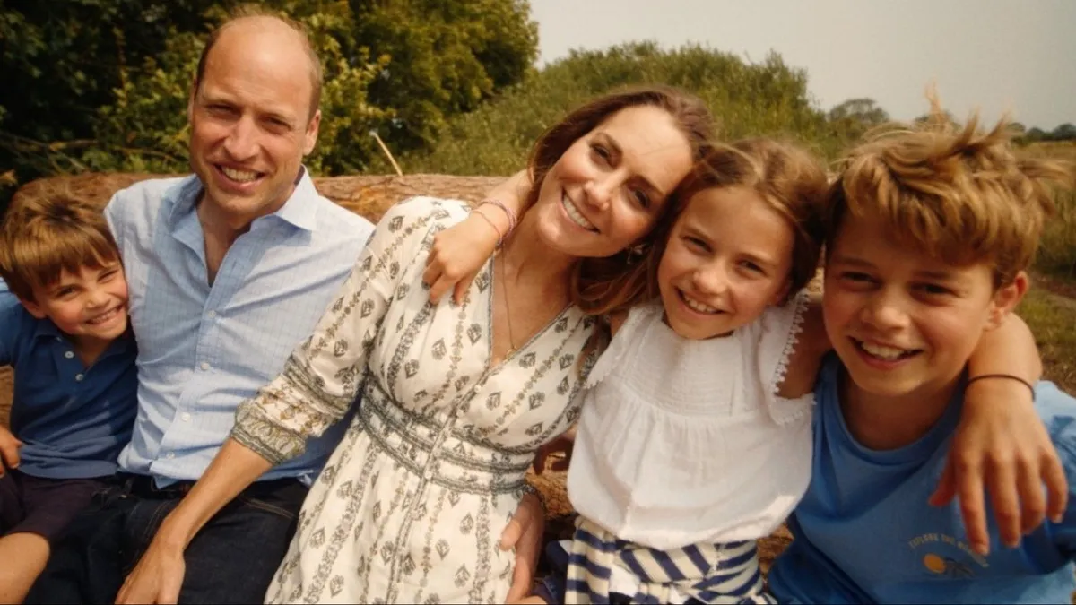 Prince Louis, Prince William, Princess Catherine, Princess Charlotte, and Prince George pose for a family photo in a field.