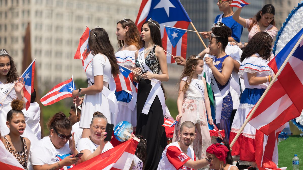 The Puerto Rican Day Parade, Puerto rican beauty queens on a float waving puerto rican flags, going down the street