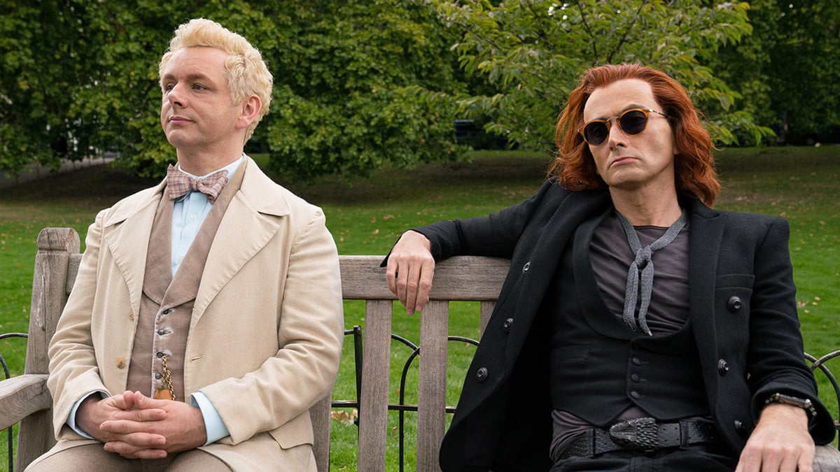 David Tennant (as Crowley) and Michael Sheen (as Aziraphale) sat on a bench in Amazon Prime TV's Good Omens