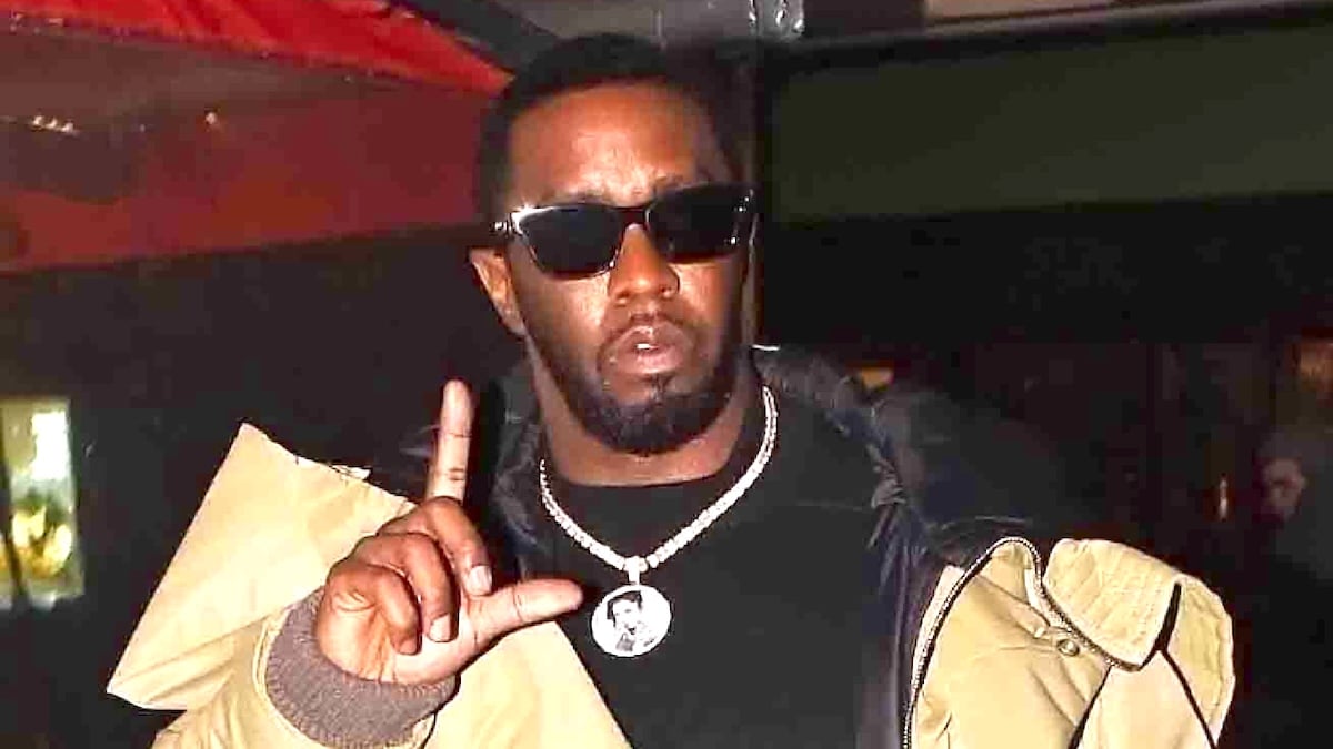 Diddy wearing sunglasses and making an L with his fingers