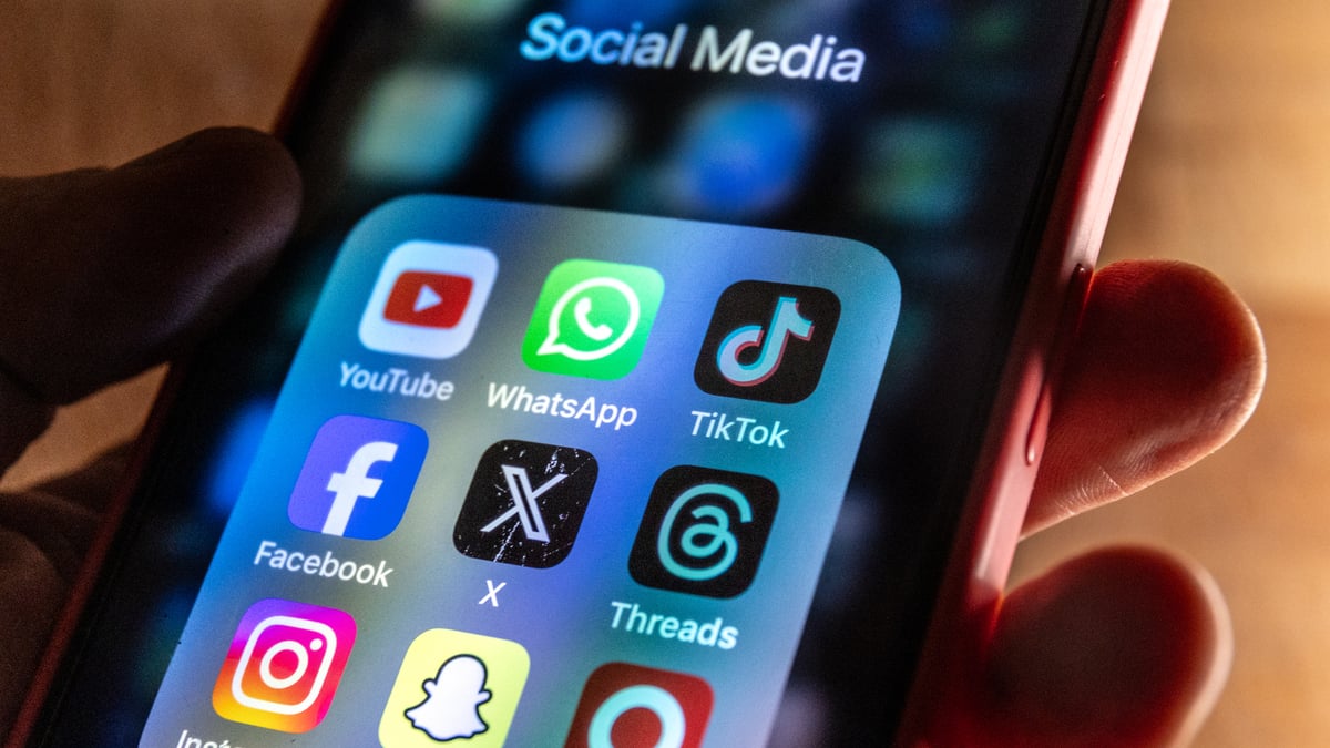 BATH, UNITED KINGDOM - MARCH 13: In this photo illustration, A man holds a smartphone iPhone screen showing various social media apps including YouTube, TikTok, Facebook, Threads, Instagram and X on March 13, 2024 in Bath, England. The US House of Representatives has passed a landmark bill that could potentially see TikTok banned in the US if the social media Chinese parent company, doesn't sell its controlling stake.