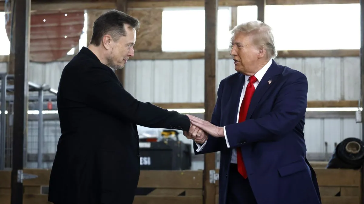 Elon Musk (L) shakes hands with Republican presidential nominee, former President Donald Trump back stage during a campaign rally at the Butler Farm Show grounds on October 05, 2024 in Butler, Pennsylvania. This is the first time that Trump has returned to Butler since he was injured during an attempted assassination on July 13. (Photo by Anna Moneymaker/Getty Images)