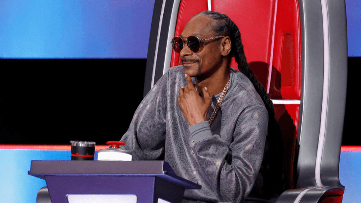 Snoop Dogg smiles while sitting in his chair on NBC's 'The Voice.'