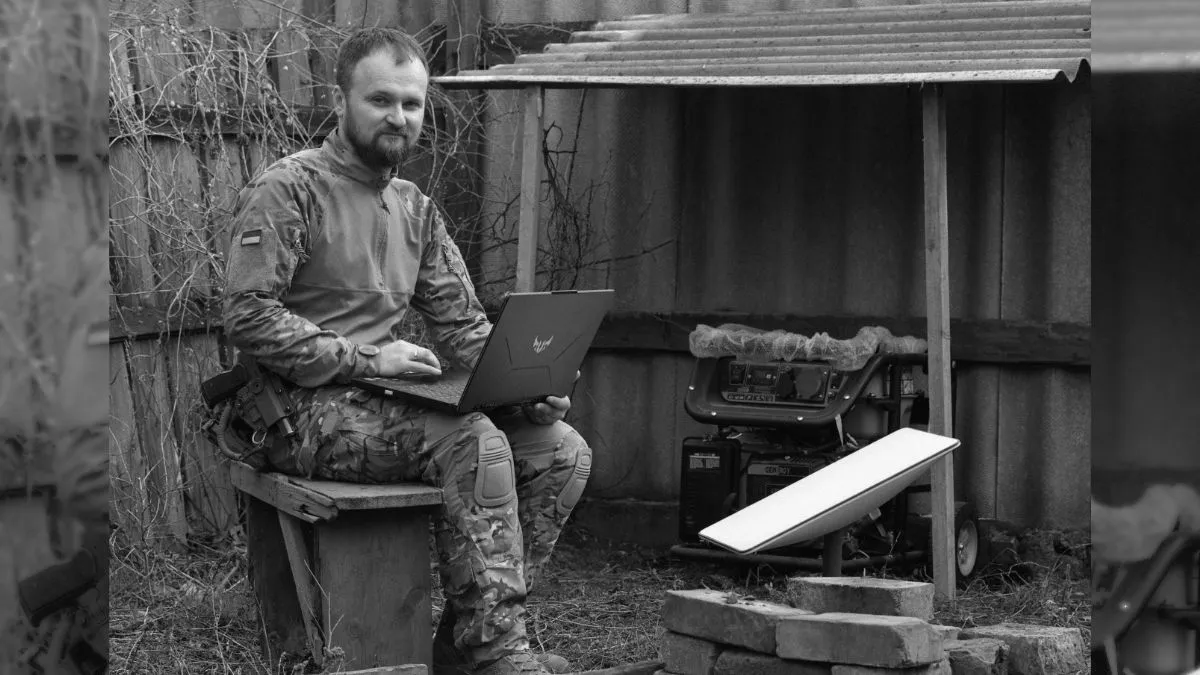 A Ukrainian soldier in front of a Starlink transmitter