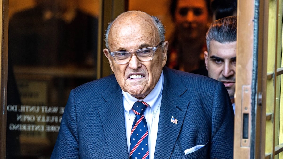 Rudy Giuliani looking like he wants to bit someone's ear off in a blue suit and tie