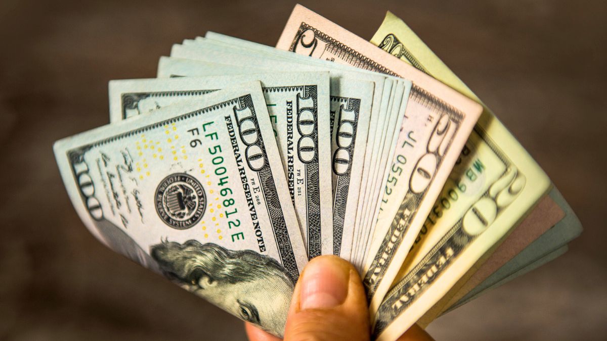 Unrecognizable mature man holding US Dollar bills. High angle view. Horizontal composition. Image taken with Nikon D800 and developed from RAW format.