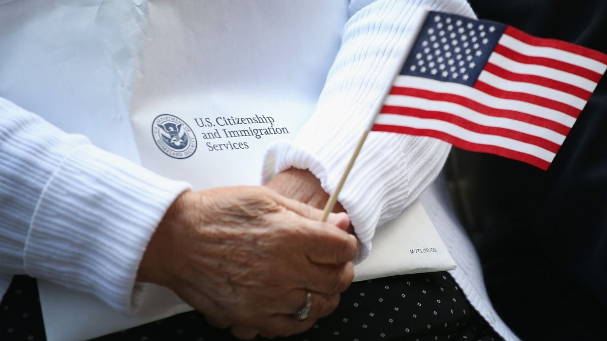 An elderly woman holds her immigration packet