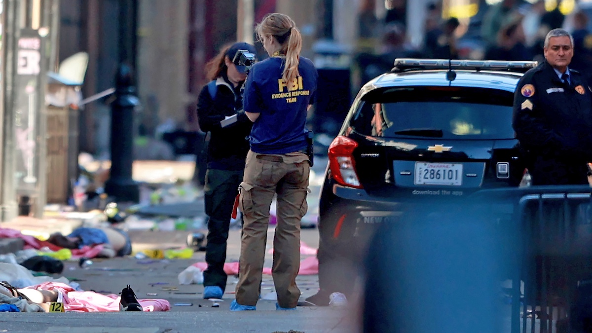 NEW ORLEANS, LOUISIANA - JANUARY 1: A member of the FBI’s Evidence Response Teams take photographs near a pair of bodies on Bourbon Street after at least ten people were killed when a driver drove into the crowd in the early morning hours of New Year’s Day on January 1, 2025 in New Orleans, Louisiana.