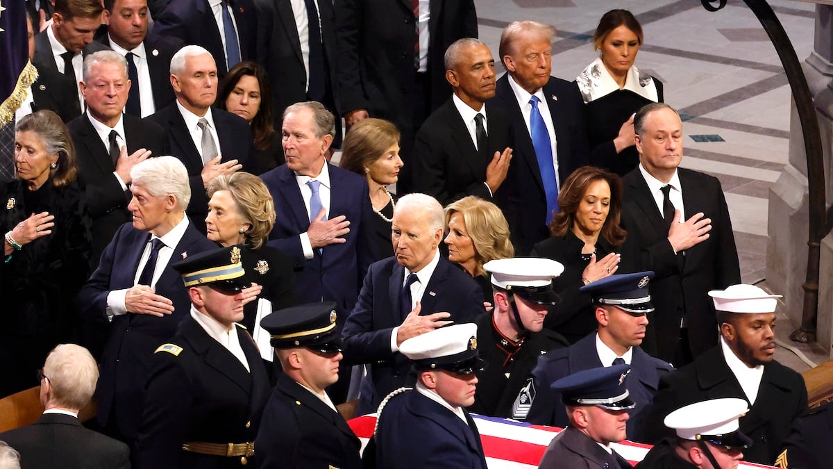 WASHINGTON, DC - JANUARY 09: U.S. Military body bearers carry the flag-draped casket bearing the remains of former U.S. President Jimmy Carter from the Washington National Cathedral during his state funeral as (L-R) Marilyn Quayle, former U.S. Vice Presidents Al Gore and Mike Pence, Karen Pence, former U.S. President Bill Clinton, former Secretary of State Hillary Clinton, former U.S. President George W. Bush, Laura Bush, former U.S. President Barack Obama, U.S. President-elect Donald Trump, Melania Trump, U.S. President Joe Biden, first lady Jill Biden U.S. Vice President Kamala Harris and second gentleman Doug Emhoff look on on January 09, 2025 in Washington, DC. President Joe Biden declared today a national day of mourning for Carter, the 39th President of the United States, who died at the age of 100 on December 29, 2024 at his home in Plains, Georgia.