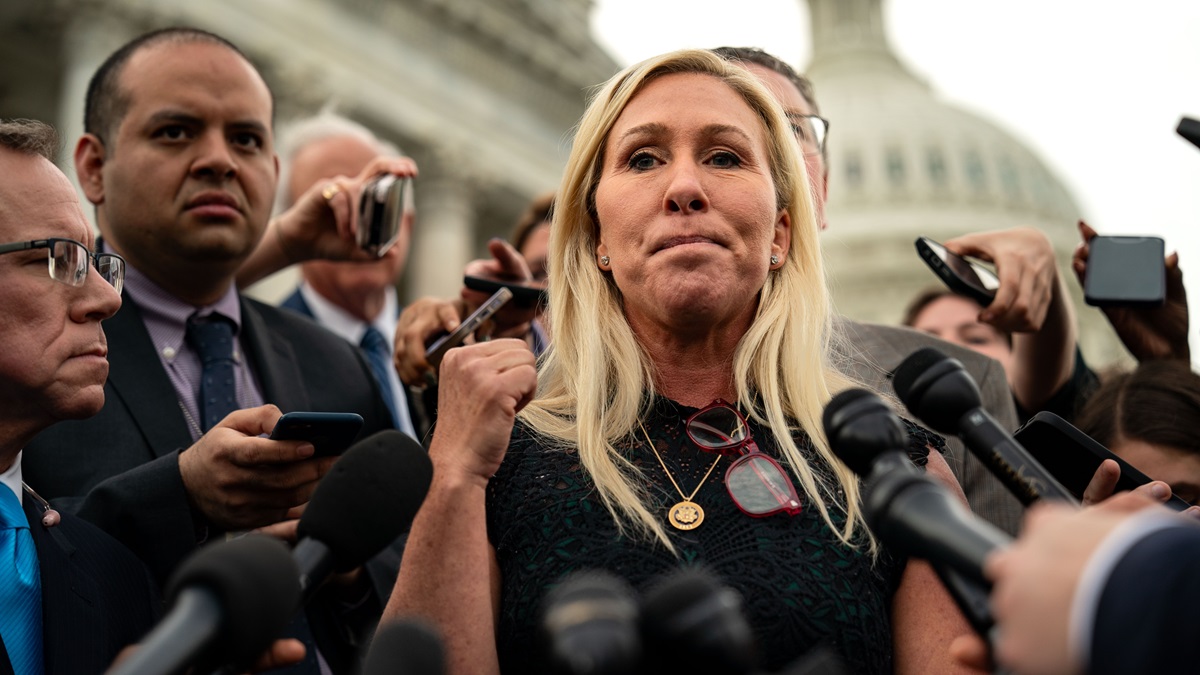 WASHINGTON, DC - MAY 8: Rep. Marjorie Taylor Greene (R-GA), and Rep. Thomas Massie (R-KY) (behind), speak to members of the press on the steps of the House of Representatives at the U.S. Capitol on May 8, 2024 in Washington, DC.