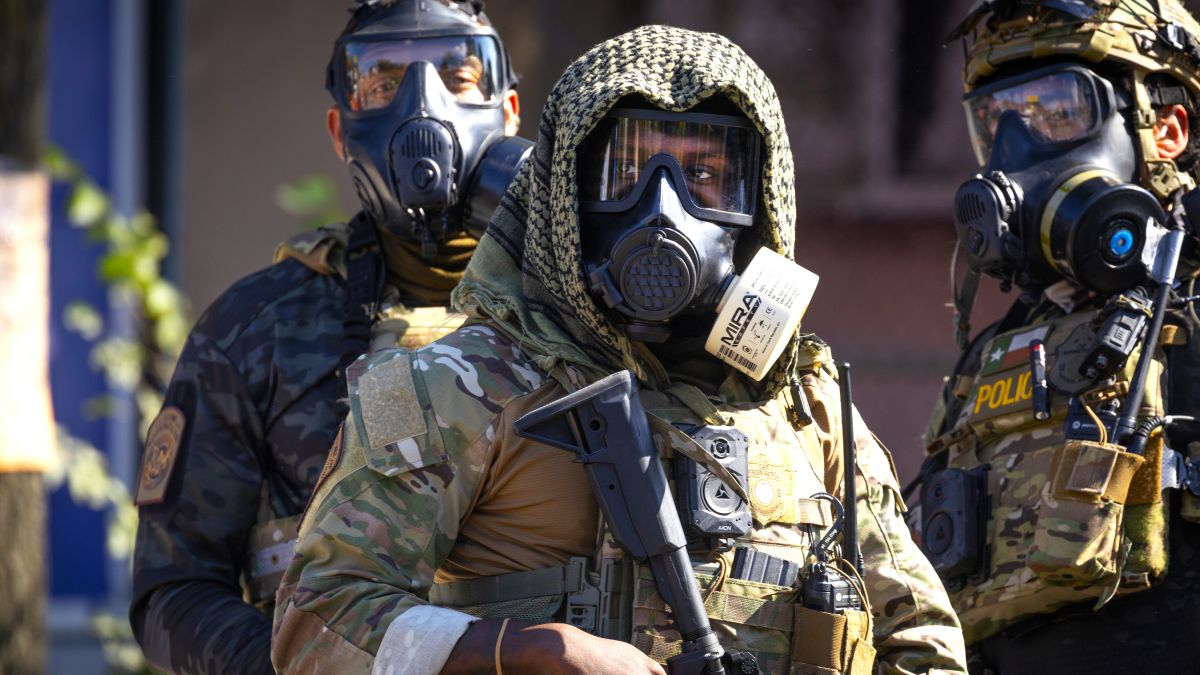 Federal law enforcement agents stand guard as they are confronted by community members and activists for reportedly shooting a woman in the Brighton Park neighborhood on October 04, 2025 in Broadview, Illinois. Residents of the city have become increasingly concerned as Operation Midway Blitz continues in the Chicago area, an operation designed to apprehend and deport undocumented immigrants living in the area. (Photo by Scott Olson/Getty Images)